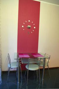 tavolo e sedie con orologio sul muro di Apartment Dekabrystiv a Mykolaïv
