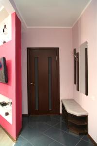 una camera con porta, panca e pareti rosa di Apartment Dekabrystiv a Mykolaïv