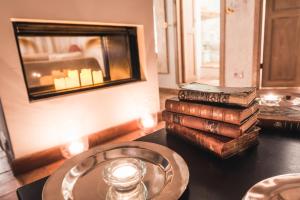 a stack of books sitting on a table with a candle at Borgo degli Ulivi in Porto Ercole