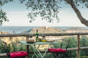 a table with a bottle of wine and two chairs at Borgo degli Ulivi in Porto Ercole