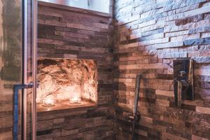 a bathroom with a brick wall and a shower with candles at Borgo degli Ulivi in Porto Ercole