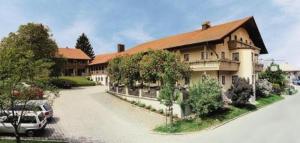 une grande maison avec une voiture garée devant elle dans l'établissement Gasthof Mayrwirt, à Saaldorf