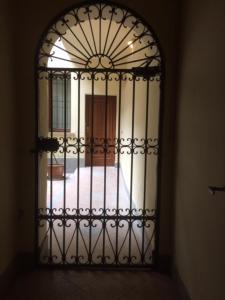 an iron gate in a room with a bedroom at Suite del Borgo - Affittacamere - Guest house in Bologna