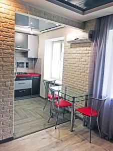 a kitchen with a table and chairs and a brick wall at Apartment on Pushkina (Prospect Soborniy) in Zaporozhye