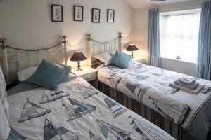 two twin beds in a room with two lamps at The Sandgate in Skegness +102 photos