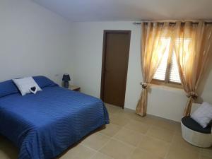 a bedroom with a blue bed and a window at Fiore di Loto in Limatola