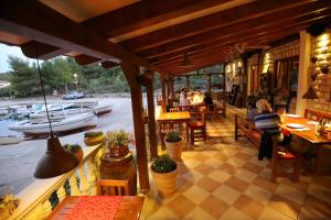 Restauracja z ludźmi siedzącymi przy stołach i rzeką w obiekcie Apartment and rooms Roko w mieście Zaglav