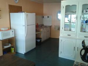 cocina con nevera blanca y microondas en Capricorn Motel Royale 1000 Islands en Lansdowne