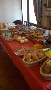 a table with a red table cloth with food on it at Hotel La Loggia in Mestrino