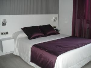 A bed or beds in a room at Hotel Rural Villa de Berlanga