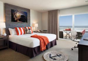 a hotel room with a bed and a desk and a window at Pacific Edge Hotel on Laguna Beach in Laguna Beach