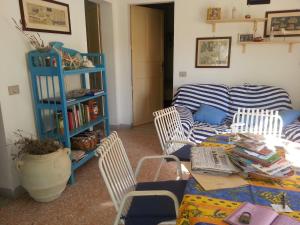 カヴァ・ダリーガにあるUn Giardino Di Pomelie Sul Mareのリビングルーム(ソファ、椅子、テーブル付)