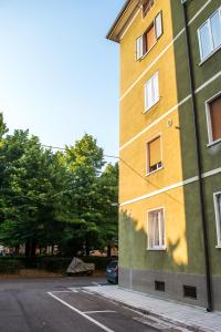 un edificio giallo e verde accanto a un parcheggio di Casa Ferrovieri a Verona