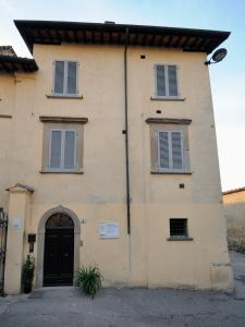 a building with a black door and two windows at Residence San Bartolomeo in Città di Castello
