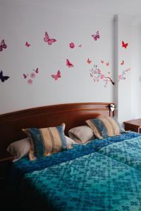 a bedroom with a bed with butterflies on the wall at Hostal El Puerto in Caleta De Velez