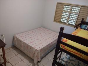 a small bedroom with a bed and a window at Casa beira thermas in Olímpia