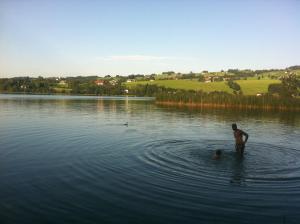 Ein Mann steht im Wasser in einem See. in der Unterkunft Pension Zenzlgut in Tiefgraben