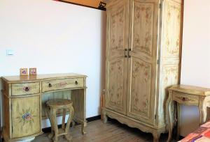 a room with a wooden cabinet and a stool and a table at Ma-Bebe SPA Suite - Thermal Jacuzzi and Family Comfort in Pchelin +10 photos