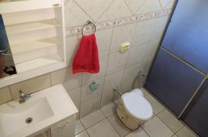 a bathroom with a toilet and a sink and a red towel at Casa beira thermas in Olímpia