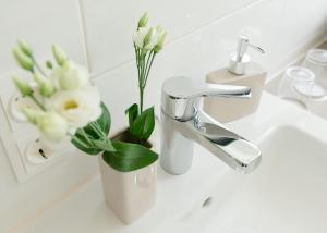 ein Waschbecken mit einer Vase mit Blumen im Bad in der Unterkunft Arion-Thale in Thale + 19 Fotos