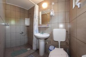 a small bathroom with a toilet and a sink at Casa Panos in 2 Mai +51 photos