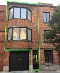 a brick building with two windows and a garage at Maison d'O in Ostend