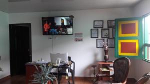 a living room with a desk and a tv on the wall at Hostal Casa de Los Taitas in Salento