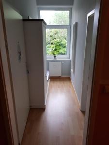 an empty hallway with a window and a wooden floor at Pension Fischerjung in Rostock