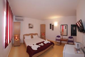 a bedroom with a bed with towels on it at Casa Panos in 2 Mai