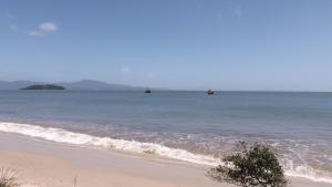 una playa con dos barcos en el agua en Apartamento Verão Canasvieiras, en Florianópolis