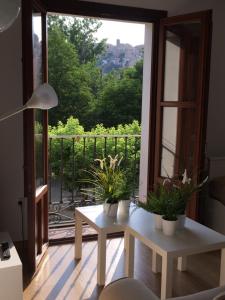 un soggiorno con un tavolo e una grande finestra di Apartamentos Viejo Continente a Cuenca