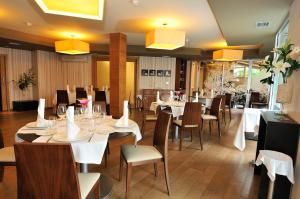 un restaurante con mesas y sillas blancas y luces amarillas en Hotel Spa Norat O Grove 3* Superior, en O Grove