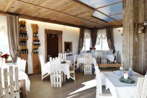 a dining room with white tables and white chairs at B&B 3409ft Aeroporto in Asiago