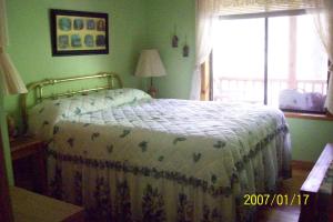 een slaapkamer met een bed in een kamer met een raam bij Garden of Eden Cabins in Cosby