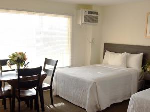 モントークにあるA Wave Inn - Montaukのベッドルーム1室(ベッド1台、テーブル、椅子付)