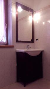 ein Bad mit einem Waschbecken und einem Spiegel in der Unterkunft Al Fiume in Arco