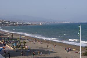 a group of people on a beach near the ocean at Hotel Doña Luisa in San Luis de Sabinillas