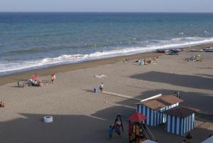 a group of people on a beach near the ocean at Hotel Doña Luisa in San Luis de Sabinillas