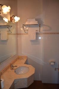 y baño con lavabo y espejo. en Casa Rural La Vall del Cadi en La Seu d'Urgell
