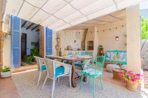 una sala da pranzo con tavolo e sedie su un patio di Ca Na Siona a Vilafranca de Bonany