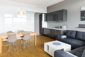 ein Wohnzimmer mit einem Sofa und einem Tisch in der Unterkunft Apartament Blue i Grey na Klifie in Ustronie Morskie