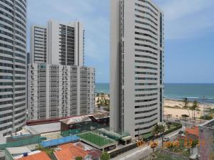 vistas a una ciudad con edificios altos y al océano en Luxuoso Quarto E Sala Mobiliado, en Recife