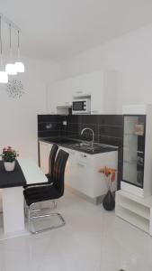 a white kitchen with a sink and a counter at Apartment & room Ivan in Šibenik