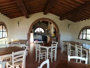 a kitchen and dining room with wooden tables and chairs at Agriturismo Il Loghino in Palaia