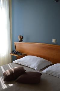 a bedroom with two beds with a wooden headboard at Evripides Hotel in Athens