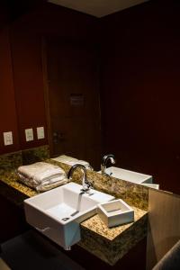 a bathroom counter with a sink and a mirror at Arte Motel (Adults Only) in Fortaleza
