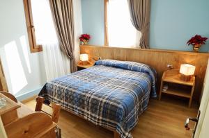 a bedroom with a bed with a blue blanket at B&B 3409ft Aeroporto in Asiago