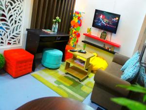 Shejoje Poshtel Hostel في مدينة سيبو: غرفة معيشة مع أريكة وطاولة وتلفزيون