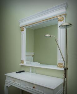 a white bathroom with a mirror and a lamp at Hotel Golden Dome Iisalmi in Iisalmi