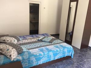 a bedroom with a bed with a blue blanket and pillows at Bungalow Eforie Nord in Eforie Nord